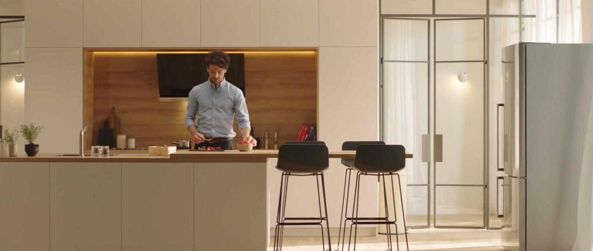 A man preparing food alone in a bright kitchen.